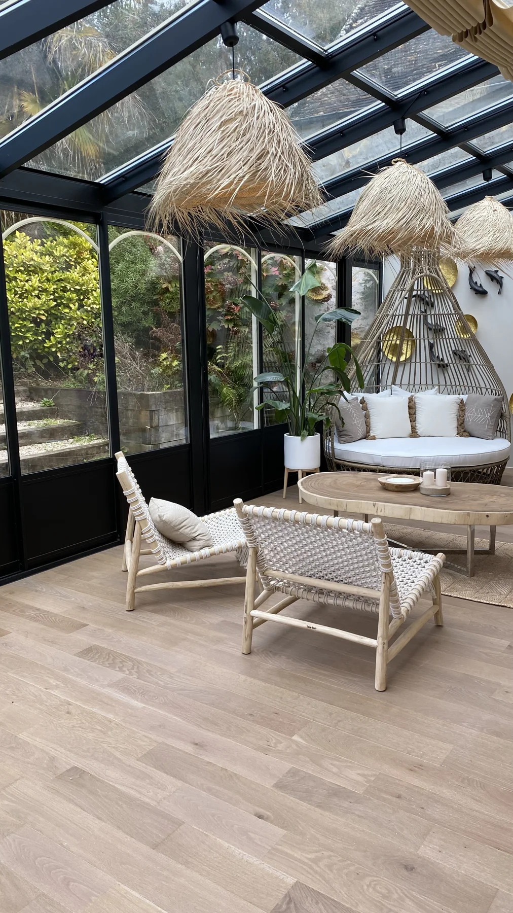 La véranda meublée de rotin, ouverte sur le jardin